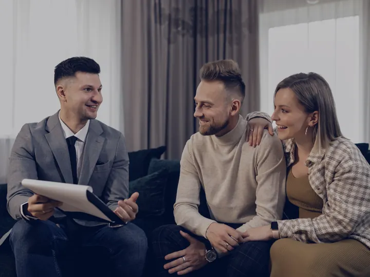 An adviser talking a couple through a quote in their living room